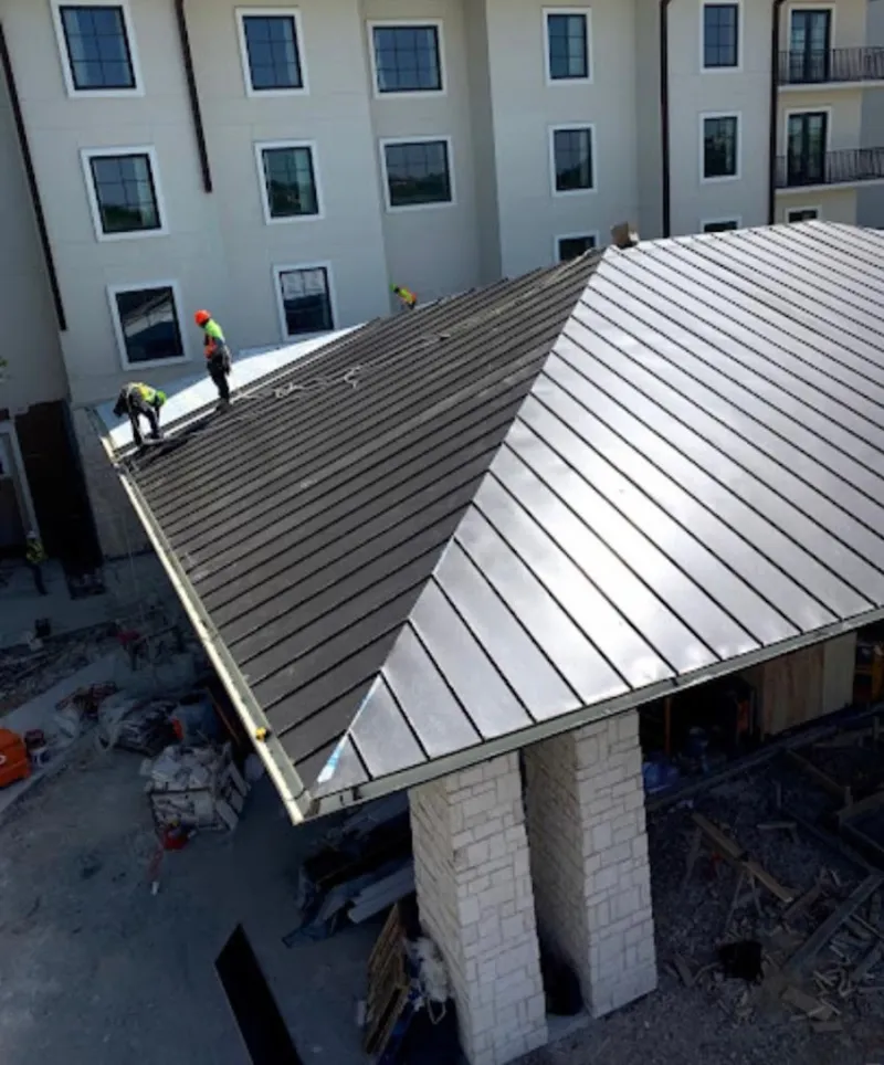 Crew installing standing seam metal roof panels on a commercial project in Rio del Mar